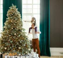 happy young father and his daughter at home with Christmas tree photo