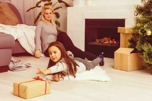 Christmas concept - mom and daughter going to open Christmas giftboxes photo