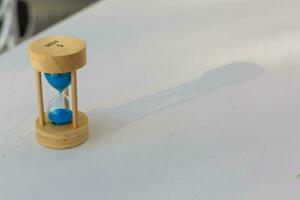 Sand running through the bulbs of an hourglass measuring the passing time in a countdown to a deadline, on a white background with copy space. photo