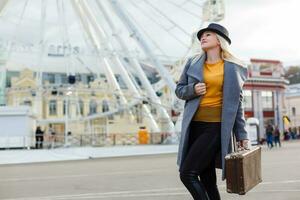 Autumn, fashion, people concept - close up of woman with brown retro suitcase walking photo