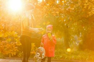 portrait of a young woman and her daughter in the autumn park photo