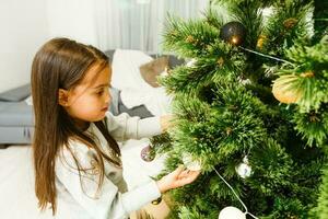 Little girl decorating the Christmas tree photo