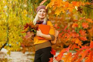 retrato de alegre joven mujer con otoño hojas en frente de follaje haciendo selfie foto