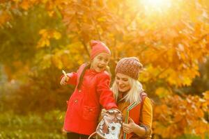 Parent take child to school. Pupil of primary school with backpack outdoors. Mother and daughter go hand in hand. Back to school. First day of fall. Elementary student. Kindergarten, preschool. photo