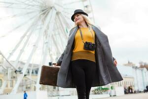 Stylish woman posing near ferris wheel photo