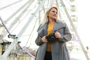 Stylish woman posing near ferris wheel photo