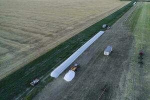 Silo bag work in pampas countryside, grain storage in La Pampa, Argentina photo