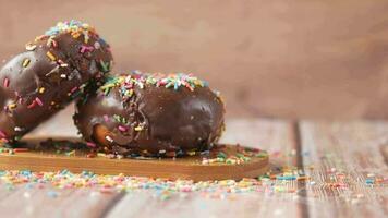 chocolate donuts with sprinkles on a wooden table video