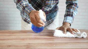 Mens schoonmaak tafel met een kleding en een fles van schoonmaak oplossing video