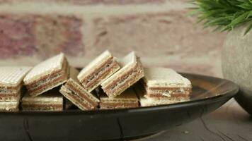 a plate of chocolate wafer on a wooden table video