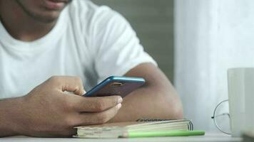 une homme est en utilisant le sien cellule téléphone tandis que séance à une table video