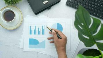 businessman's hand analyzing a paper with graphs using pen video