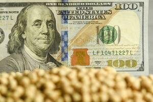 Dollars banknotes and coins and soy beans, commoditi value concept. photo