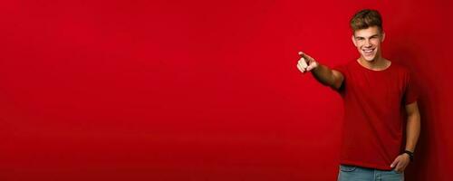 Young man pointing to empty space red background photo