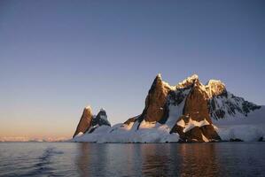 Lemaire strait coastal landscape, mountains and icebergs, Antarctic Peninsula, Antartica. photo