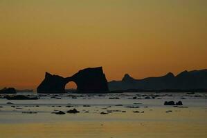 Lemaire strait coastal landscape, mountains and icebergs, Antarctic Peninsula, Antartica. photo