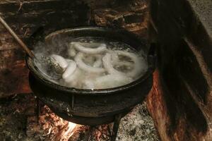 Cooking white blood sausage, in an iron saucepan, on a stove. photo