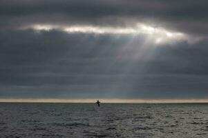 rayos de sol después un tormenta en el océano, Patagonia, argentina foto