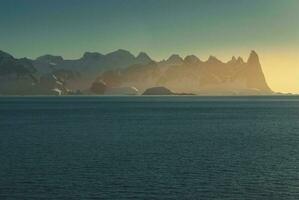 Lemaire strait coastal landscape, mountains and icebergs, Antarctic Peninsula, Antartica. photo