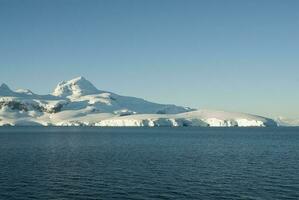 Lemaire strait coastal landscape, mountains and icebergs, Antarctic Peninsula, Antartica. photo