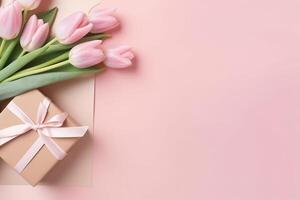 Top view of gift boxes with bows bouquets of tulips envelope with postcard and sprinkles on isolated pastel pink background with copy space, photo