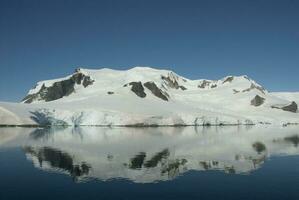 Snowy mountains in Paraiso Bay, Antartica. photo