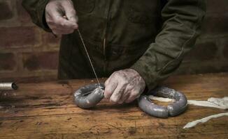 Hands making homemade sausages, Patagonia, Argentina photo