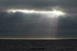 Sunbeams after a storm in the ocean, Patagonia, Argentina photo