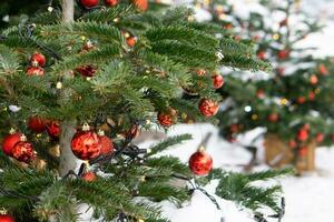 Christmas trees decorated with red balloons in front of the entrance to the cafe. Street Christmas decorations photo