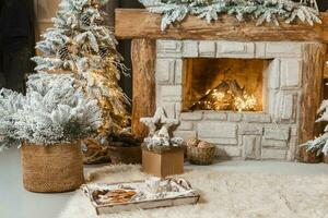 The interior of a room with a fireplace, Christmas trees with artificial snow and garlands, a blanket and a tray with hot drinks. The magical atmosphere of Christmas. photo