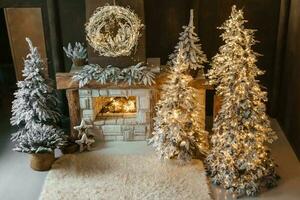 The interior of a room with a fireplace, Christmas trees with artificial snow and garlands. The magical atmosphere of Christmas. photo