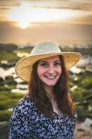 mujer con sombrero disfrutar el puesta de sol a el rocoso playa en gaia, Oporto, Portugal. juni 17 2023. foto