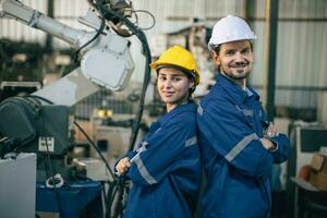 Pareja trabajador contento trabajo en equipo en pie juntos simpático sonriente disfrutar trabajando en pesado metal industria foto