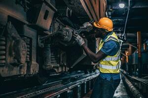 one man worker servicing replace broken part of old train at diesel locomotive repair shops photo