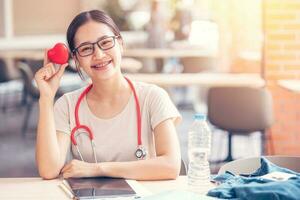 Happy cardio doctor student with red heart sign for sharing love healtcare to people concept. photo