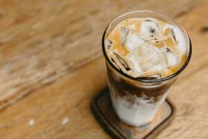 iced coffee, cold milk latte with ice on wood table background copy space for text photo