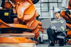 Smart engineer working woman working machine inspector with laptop computer in assembly plant photo