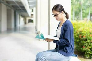 Smart woman sitting reading a book use free time for learning education bookworm nerd in university. photo