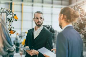 Businessman working in machinery factory robot assembly plant team working together photo