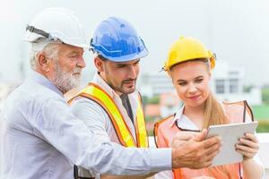 group of builder engineer and architecture using new technology of tablet for inspect building design working join together photo