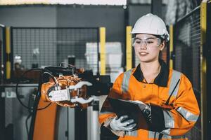 Engineer woman worker work design program machine robotic arm in automation factory industry photo
