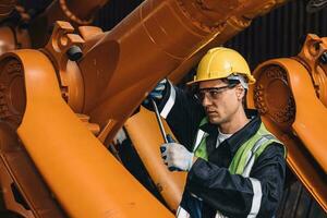 Engineer working service maintenance robot arm welding in assembly line automation factory industry. photo