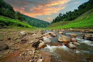 río arriba ver en parte superior de el represa rodeado por montañas y lozano naturaleza foto