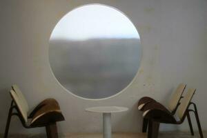 a round window with a chair and table in front of it photo