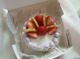 Strawberry cake with whipped cream and fresh strawberries on white plate photo