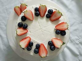 Strawberry cake with whipped cream and fresh strawberries on white plate photo