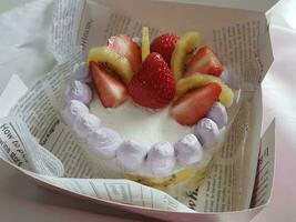 Strawberry cake with whipped cream and fresh strawberries on white plate photo