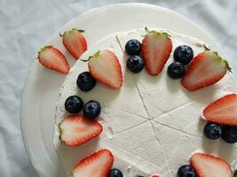 Strawberry cake with whipped cream and fresh strawberries on white plate photo