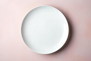 top view of an empty white plate on pink background. photo