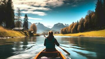 posterior ver de mujer montando canoa en corriente con antecedentes de hermosa paisaje. foto